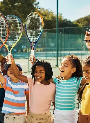 small children playing tennis
