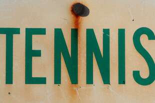 sign says tennis in green with some rust